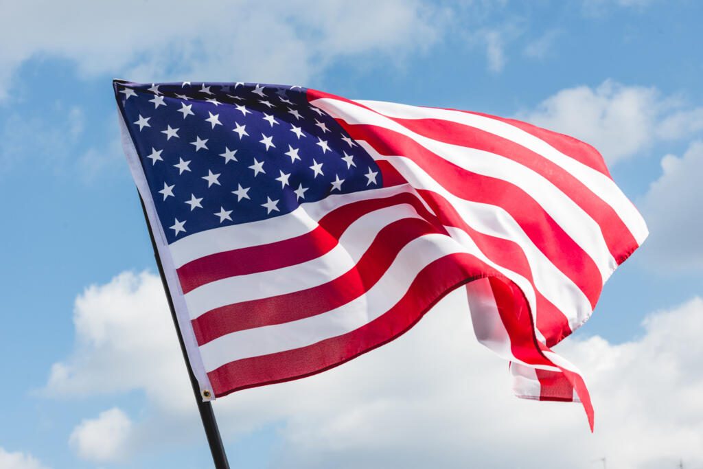 low angle view of stars and stripes on american flag against blu